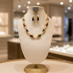 Jewelry set with necklace and earrings on a black stand in a store setting.