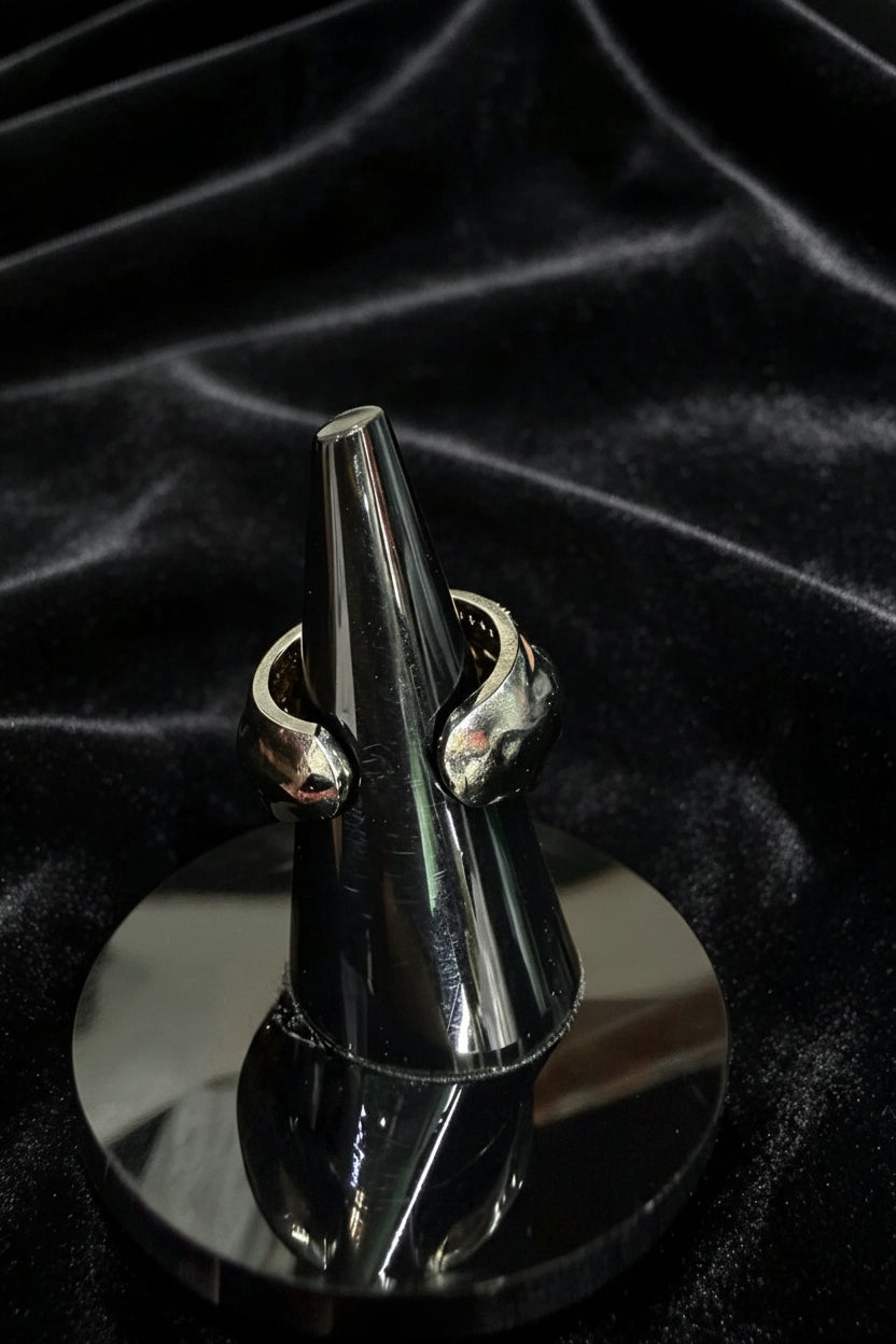Rear view of the Ziva Peridot Statement Ring displayed on a dark cone stand against a black fabric background.