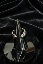 Rear view of the Ziva Peridot Statement Ring displayed on a dark cone stand against a black fabric background.
