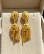 Pair of gold-plated jhumka earrings featuring detailed floral sunburst studs and hanging chain tassels, presented inside a velvet jewelry box.