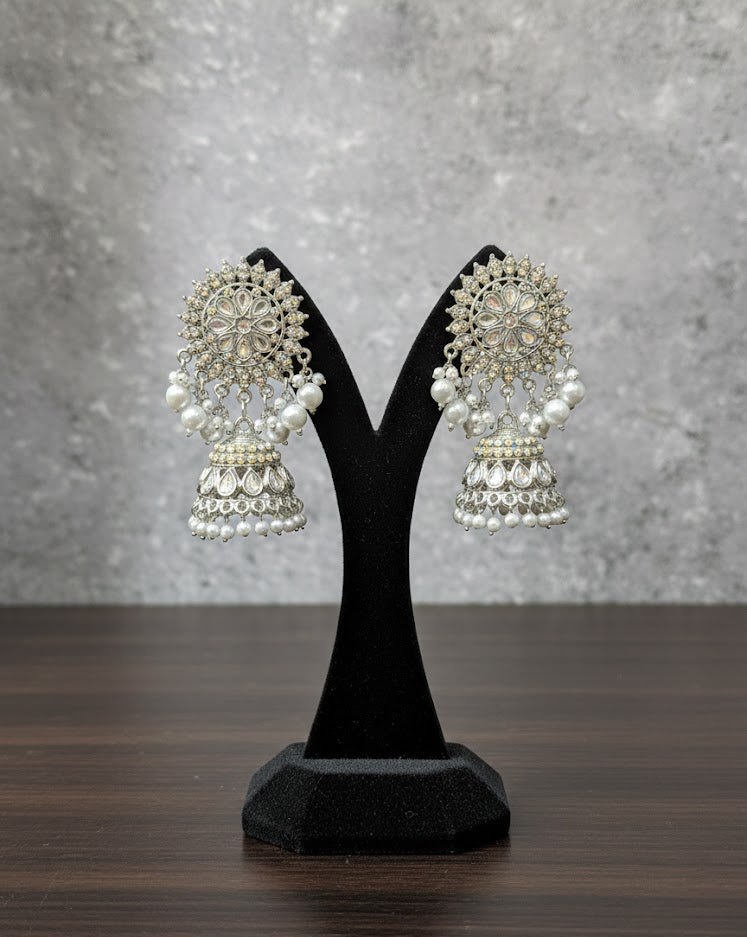 Luxury silver-polished brass earrings with high-luster pearls displayed on a minimalist velvet stand, highlighting the posh jewellery craftsmanship.