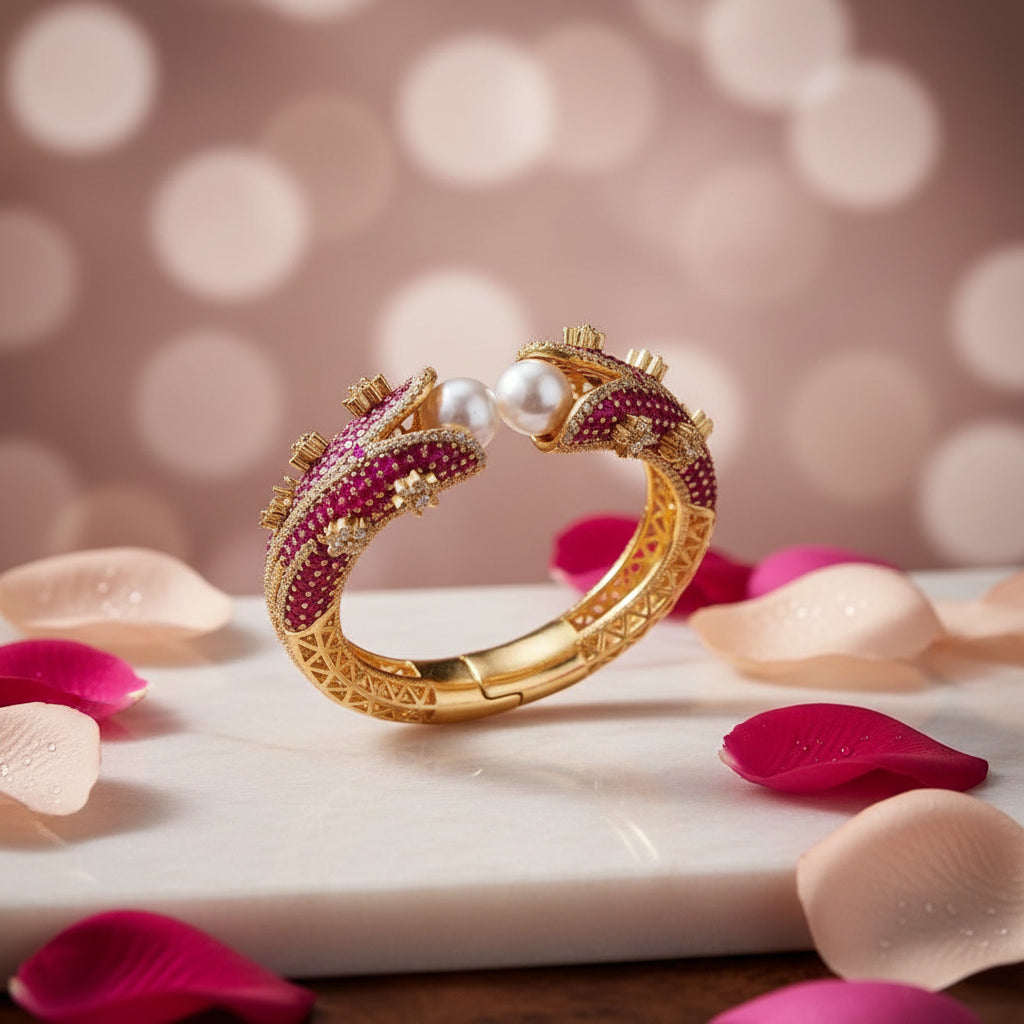 Magenta Pearl Gold Openable Bangle displayed on luxury stand — featuring rich magenta-red gemstones, lustrous pearls, and intricate gold detailing; premium bridal jewelry by Famaza Couture.