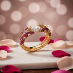 Magenta Pearl Gold Openable Bangle displayed on luxury stand — featuring rich magenta-red gemstones, lustrous pearls, and intricate gold detailing; premium bridal jewelry by Famaza Couture.