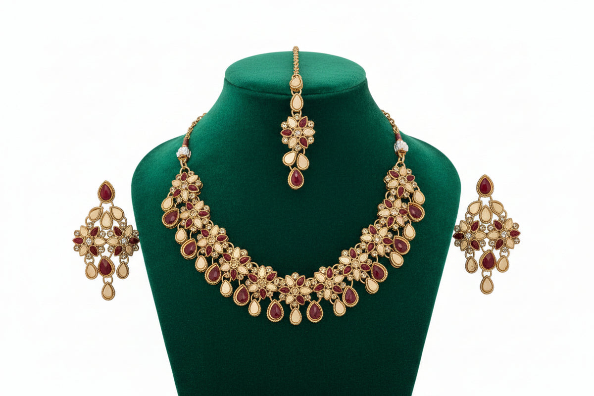 Matching golden earrings and Maang Tikka with red stone embellishments from a 3-piece bridal set.