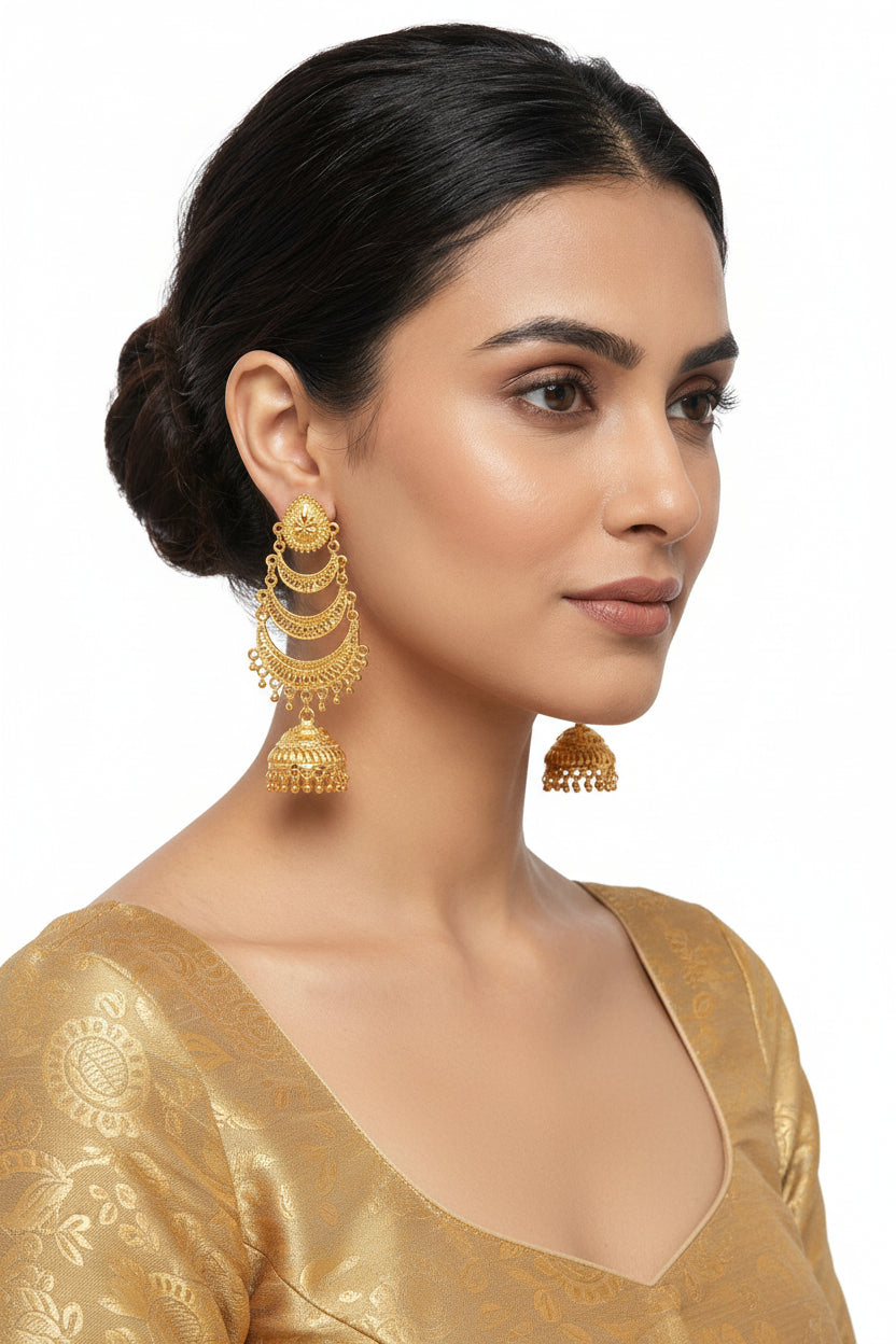Model wearing micro gold-plated tiered jhumka earrings featuring a three-layer crescent design with intricate filigree work and a bell-shaped drop.