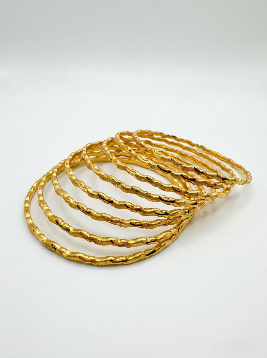 A set of 8 micro gold-plated copper bangles featuring a textured, wavy twisted-rope design, arranged in an overlapping fan shape on a clean white background.