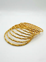 A set of 8 micro gold-plated copper bangles featuring a textured, wavy twisted-rope design, arranged in an overlapping fan shape on a clean white background.