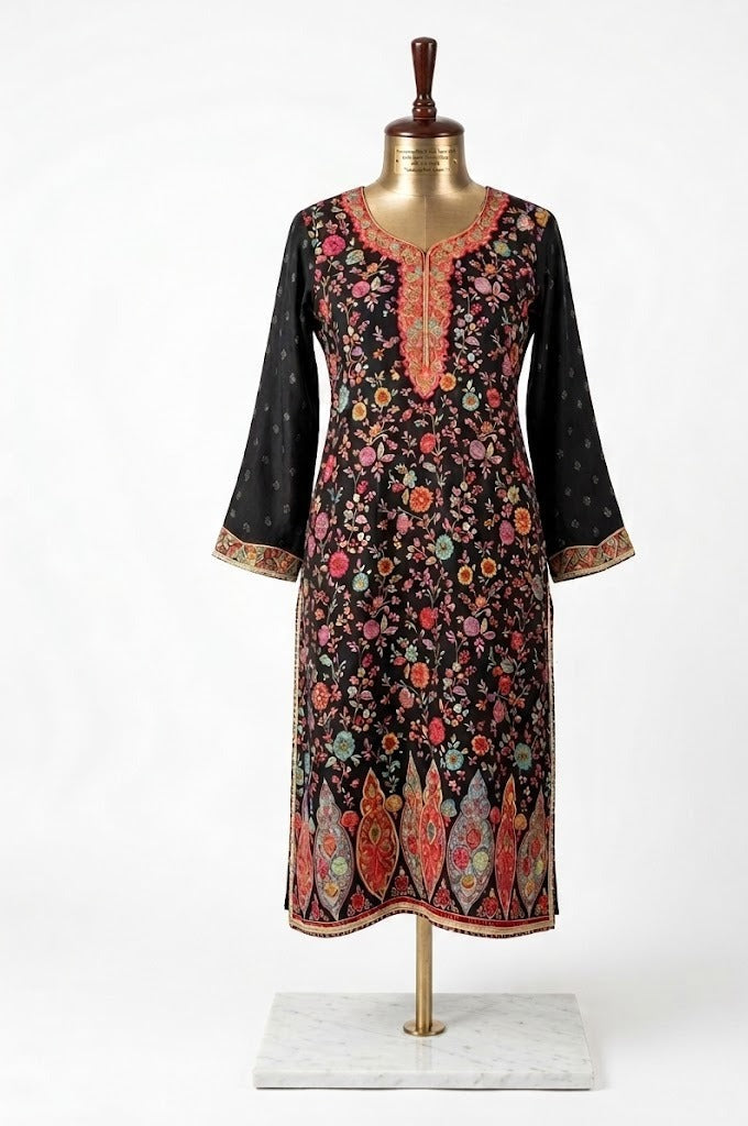 Front view of a premium black pure silk kurta featuring intricate multi-colored Kanni floral embroidery and metallic zari border work on a professional display stand.