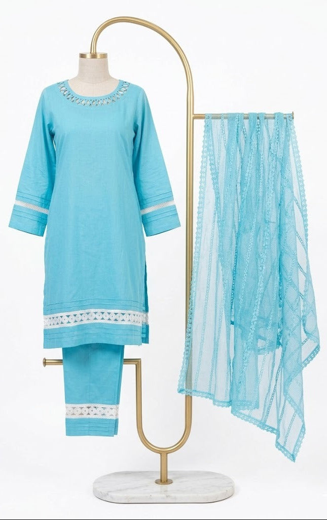 Front view of an aqua blue cotton kurta and trouser set with intricate white lace detailing on the neckline, sleeves, and hem, displayed on a gold stand with a matching net dupatta.