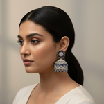 Model is wearing American diamond earrings with navy blue stones. 