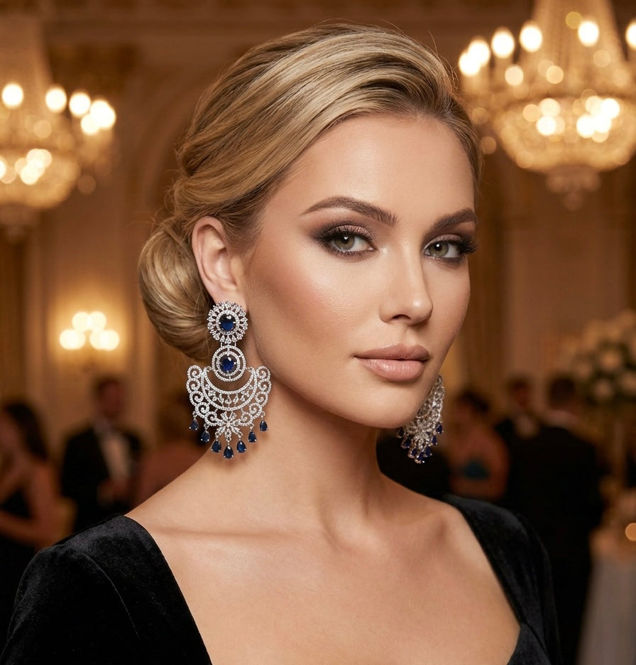 Model is wearing American diamond earrings with white and navy blue cubic zirconia stones. 