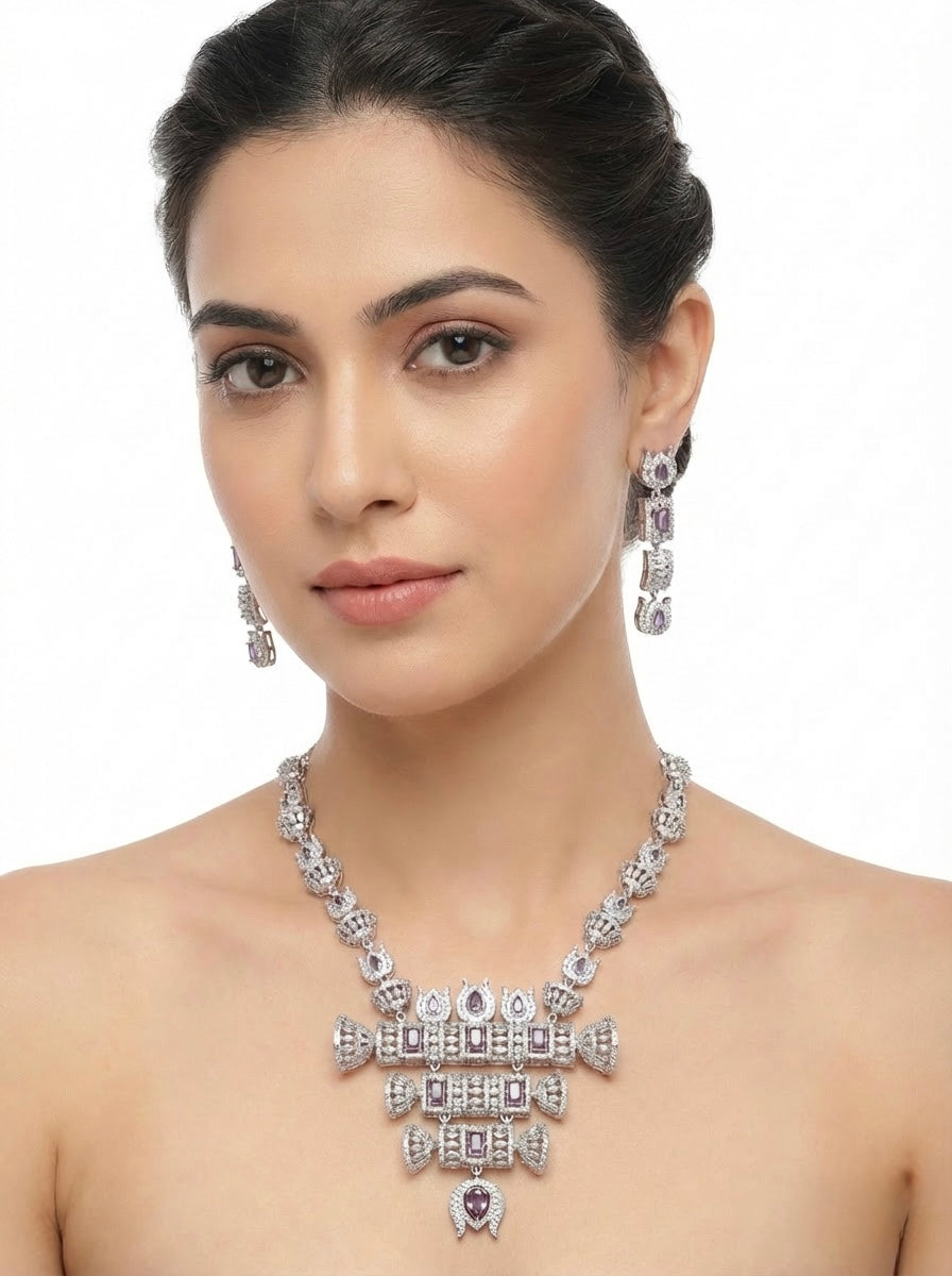 Model is wearing and displaying this American diamonds with purple cubic zirconia centre stones hasli necklace and earrings jewellery set.