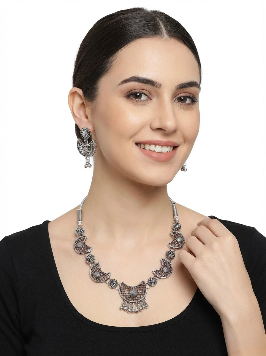 Model is wearing this oxidised chocker necklace and stud earrings jewellery set. 