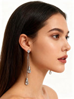 Model showcasing the dramatic 10cmsilver shoulder-dusting length of the Celestial AD white stone statement earrings.