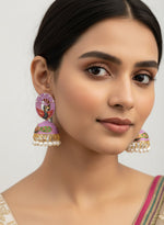 Model styling 5.5cm multi-color pink and green peacock jhumkas for a traditional festive look.