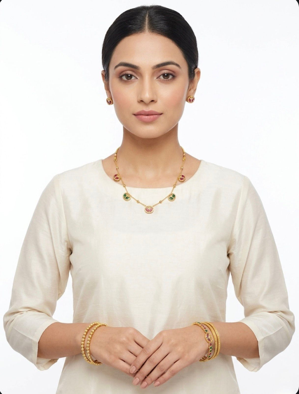  Model wearing a dainty gold-toned brass Minakari necklace set with pink and green enamel detailing and matching studs.