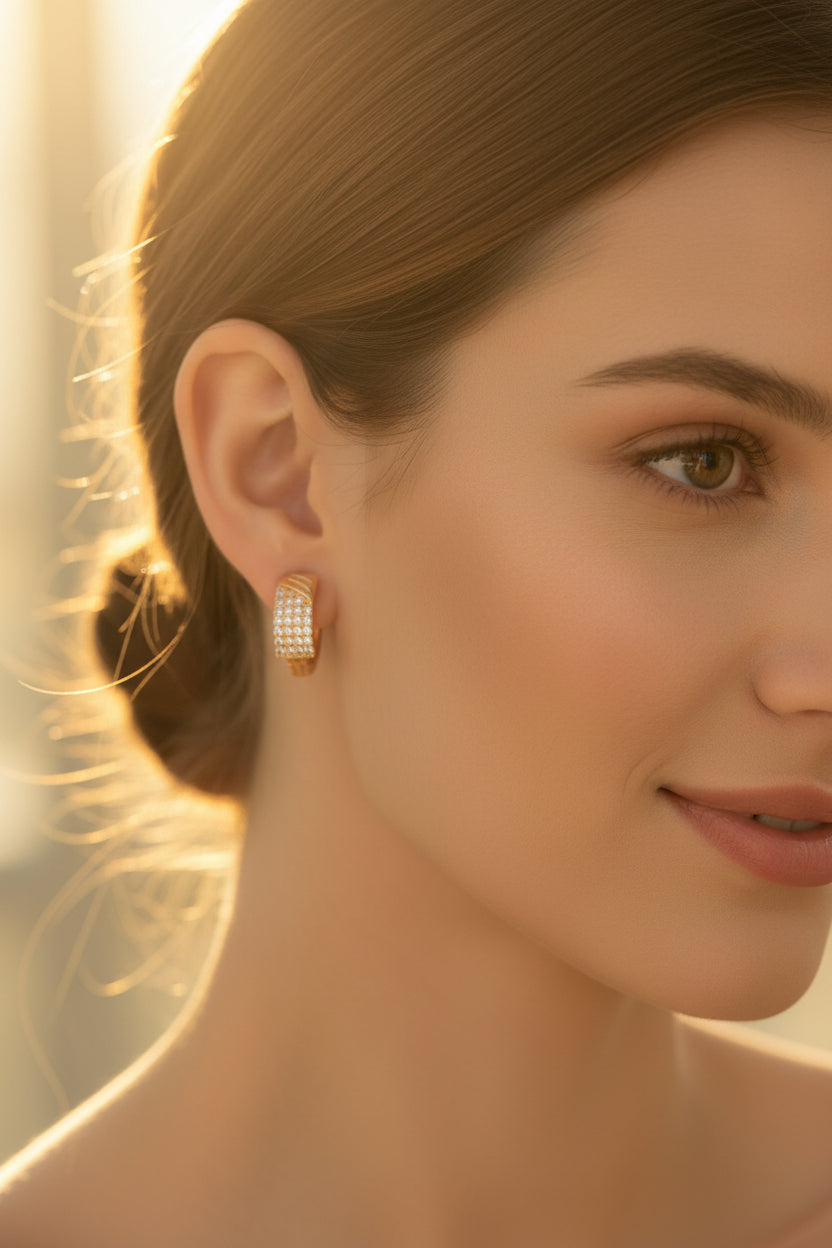 Model wearing our golden square-shaped hoop stud earrings densely set with small, sparkling crystals.