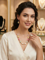 Model wearing the Famaza Couture beaded necklace set layered with a gold chain over a white linen shirt for a boho-chic style.