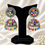 Multicolor floral mirror work meenakari oxidized silver jhumka earrings on black stand — ethnic Pakistani Indian bridal party jewelry.