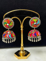 Vibrant multicolor hand-painted fan motif mirror & beadwork silver jhumka earrings with ghungroo bells on gold display stand — Famaza Couture ethnic bridal jewelry.