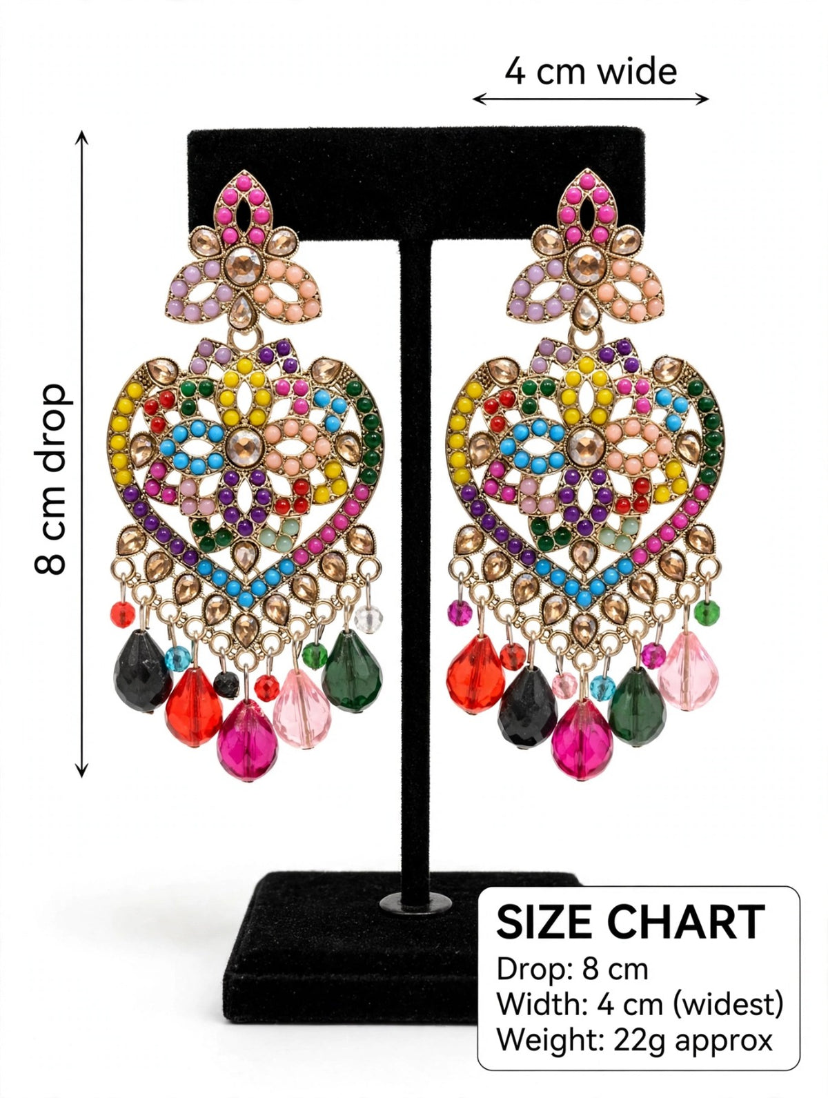Gold-tone multicolor mosaic heart chandelier earrings on black velvet display stand — 8cm drop, 4cm wide, featuring rainbow stones and teardrop bead fringe — South Asian bridal festive jewelry.