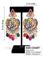 Gold-tone multicolor mosaic heart chandelier earrings on black velvet display stand — 8cm drop, 4cm wide, featuring rainbow stones and teardrop bead fringe — South Asian bridal festive jewelry.