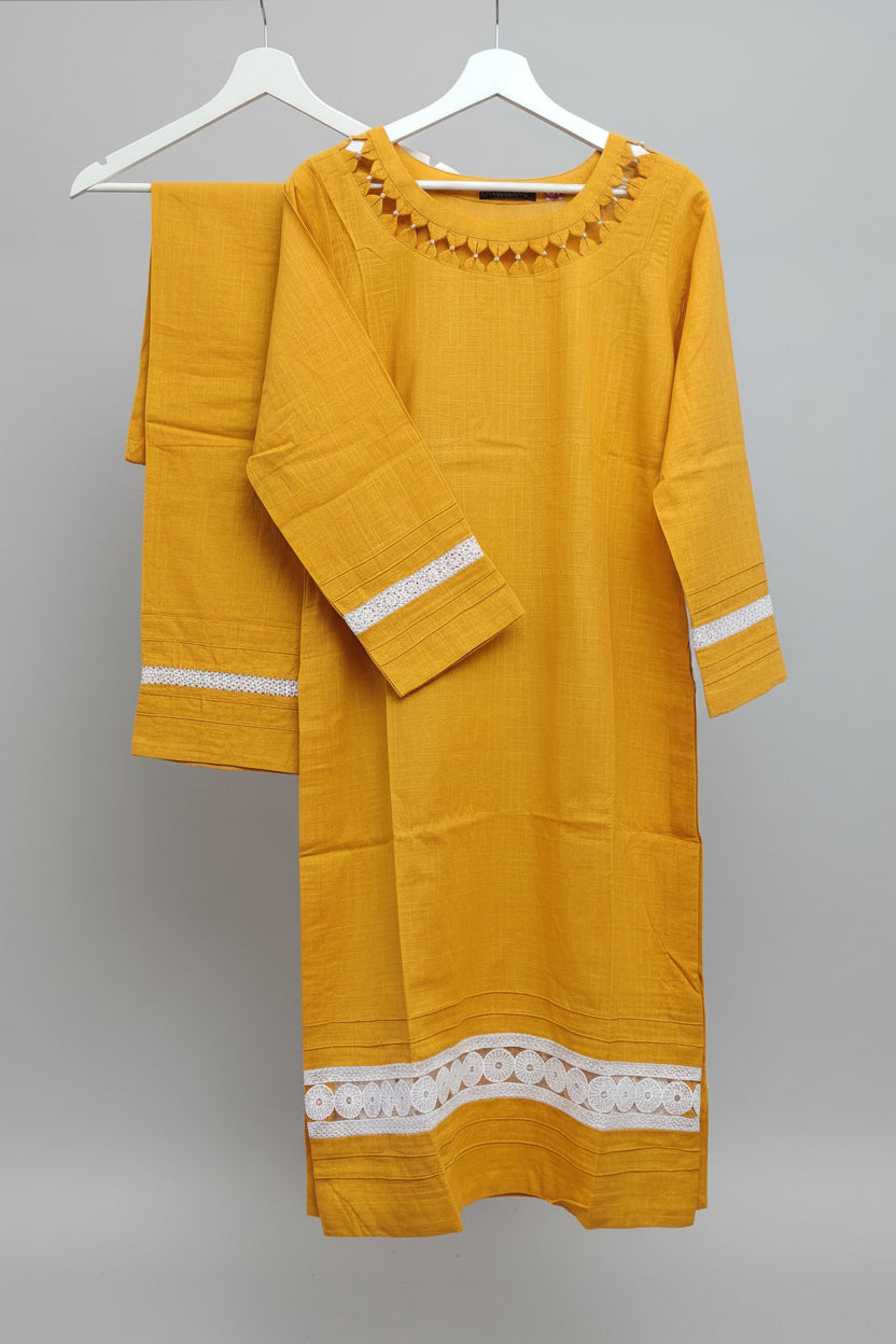 Mustard Yellow kurta with white lacein the daaman and sleeves. Trousers are hanging next to the Kurti in the hanger with white lace adorned in the bottom paincha.