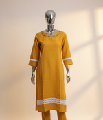Mustarad Yellow kurta with white lace details on a mannequin against a neutral background