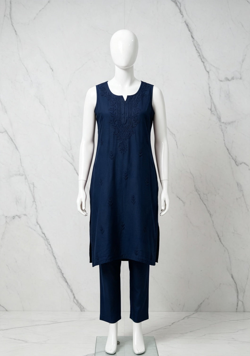 Full-length front view of the navy blue handcrafted sleeveless Chanderi silk Chikankari co-ord set displayed on a white mannequin against a marble background.