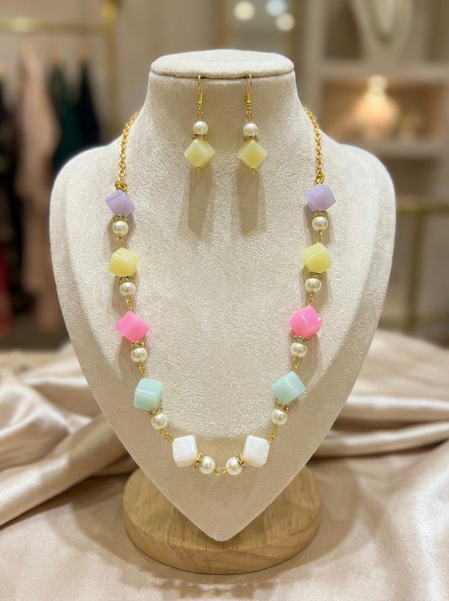 Necklace and earrings set on a mannequin bust with a blurred background