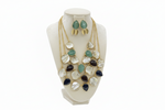 Necklace with multicolored stones on a black stand against a white background