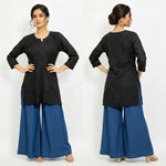 Model wearing a black short kurti featuring intricate leaf embroidery, designed as a standalone short kurti without bottom trousers.