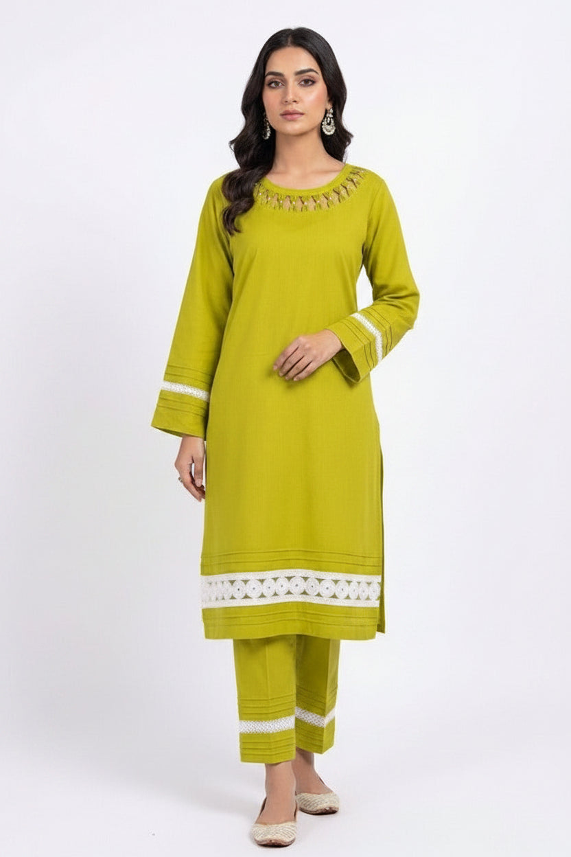 A model wearing an olive green cotton kurta set featuring white lace detailing, horizontal pintucks on sleeves and trousers, and a coordinating Kota Doriya dupatta against a pure white background.