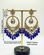 Ornate earrings with blue teardrop pendants on a stand, showing measurements and weight.