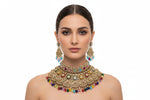Ornate jewellery set with colourful gemstones on a black stand