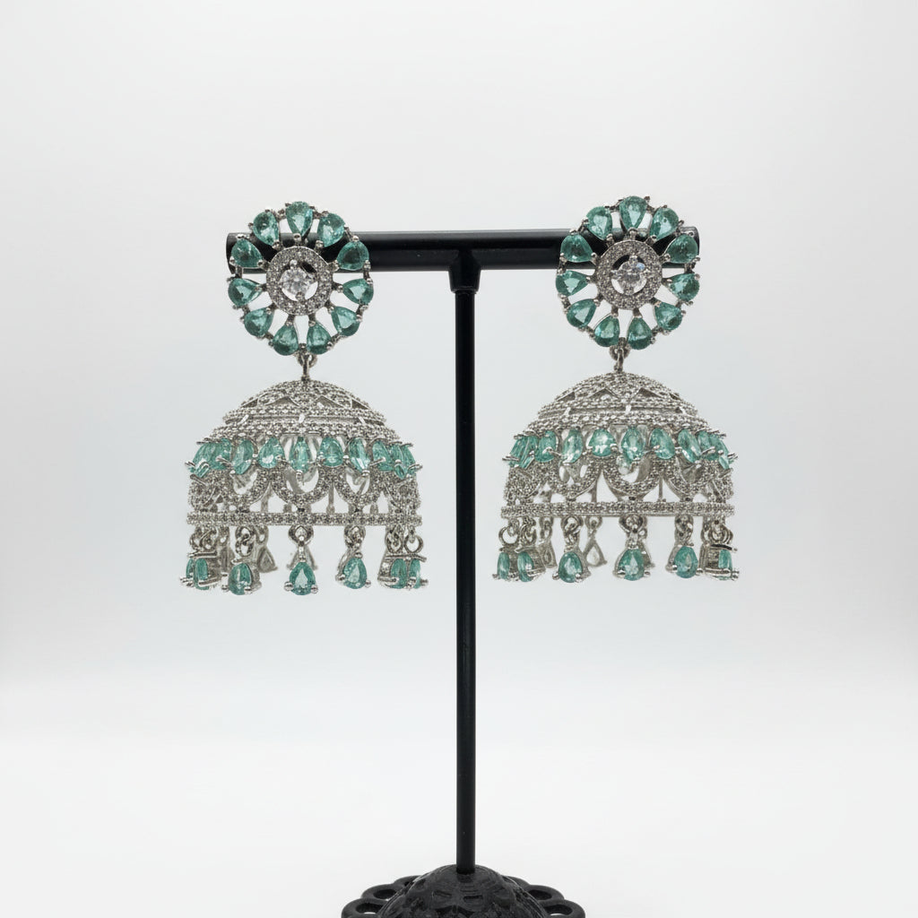 Ornate silver-toned jhumke featuring refreshing sea green marquise stones set against a brilliant white crystal framework.