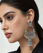Close-up of woman wearing oxidized silver tone chandbali jhumka earring — intricate filigree work, teardrop top, cascading ghungroo beads, lantern drop, traditional Pakistani Indian ethnic bridal jewelry.