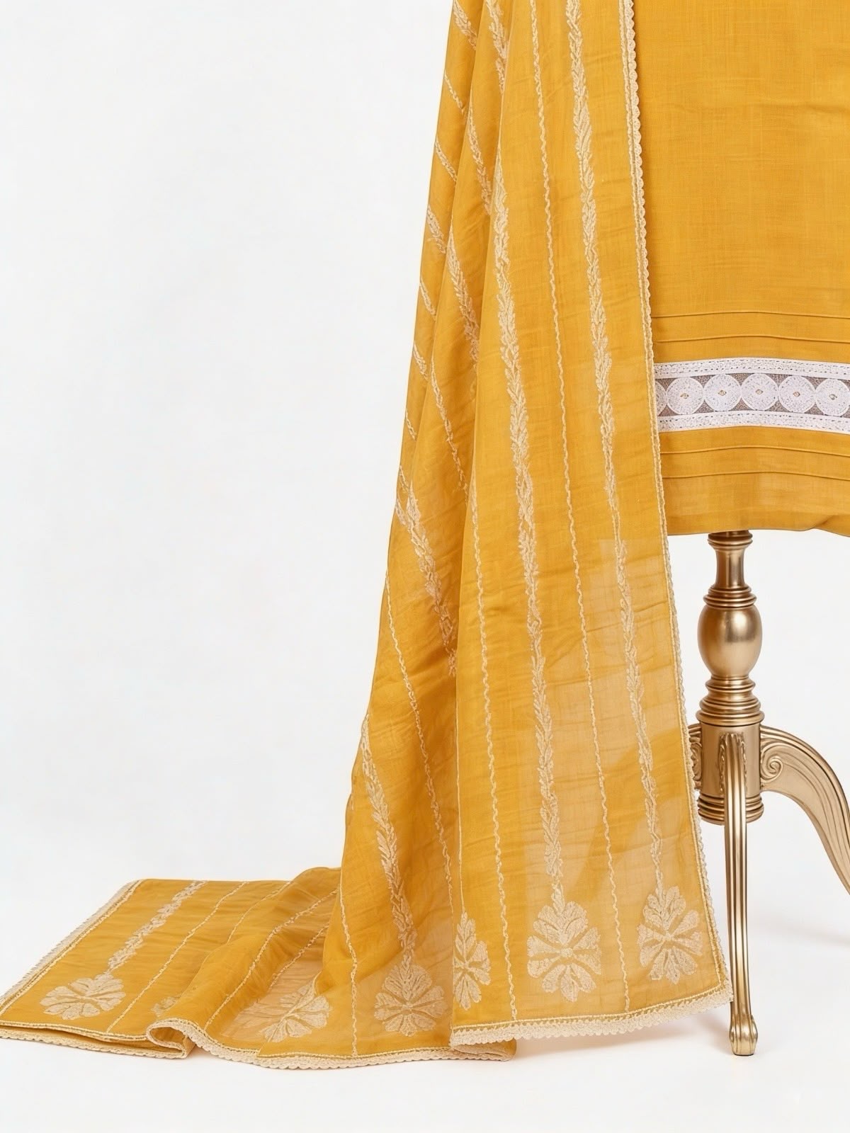 Mustard yellow fabric with white embroidery on a white background