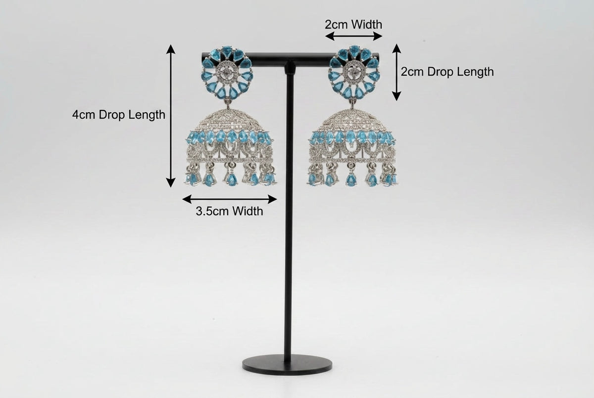 Pair of American diamond earrings with skyblue stone on a stand with measurements indicated.