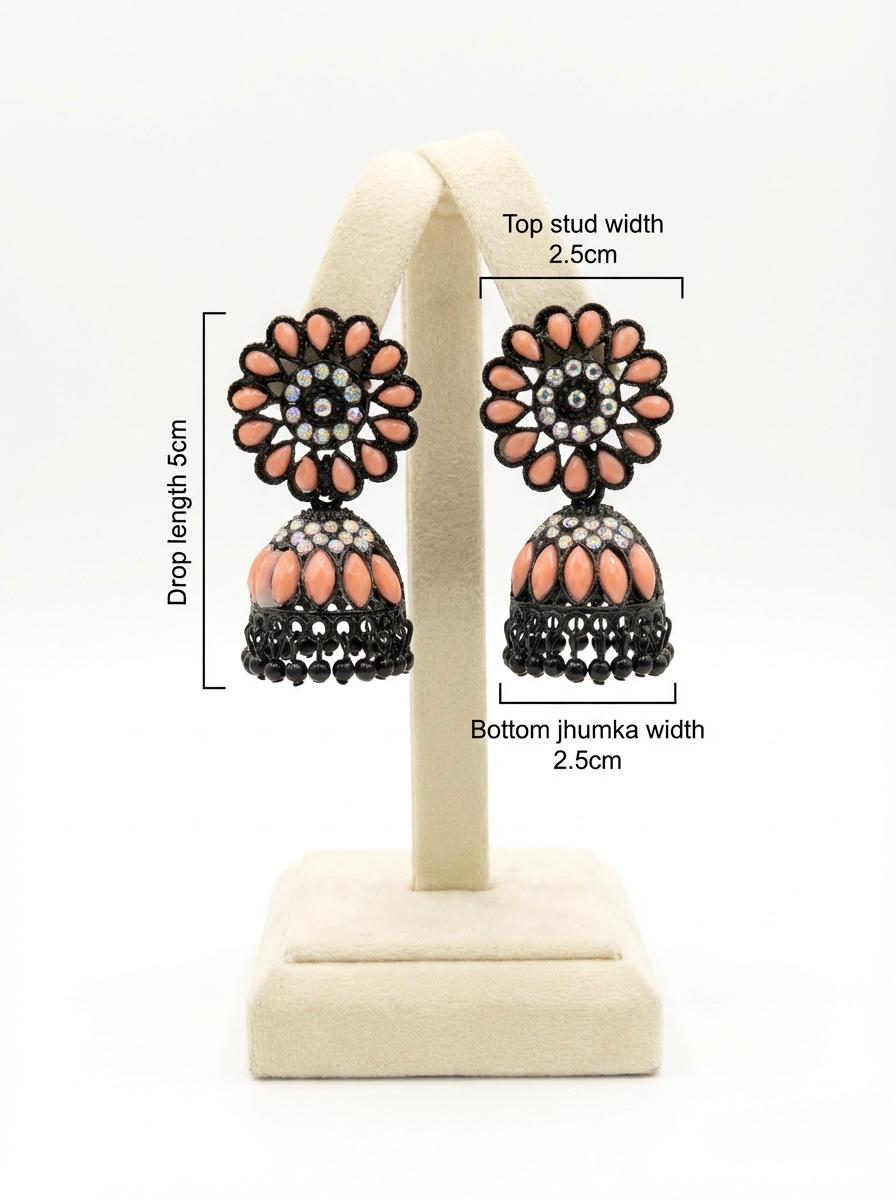  Pair of black brass jhumka earrings displayed on a stand, showcasing a soft peach floral stone stud and matching peach-accented jhumka base.