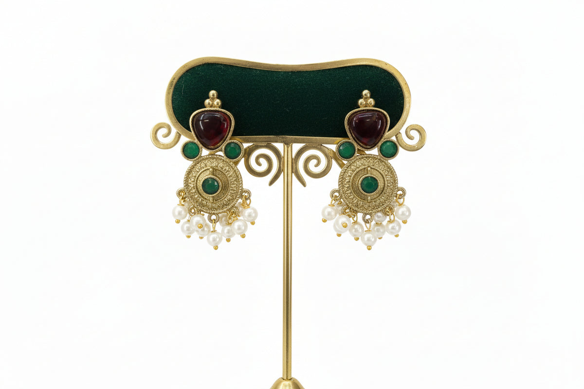 Pair of gold and maroon earrings with 3 tiny green stones and nano pearls hangings in the bottom.