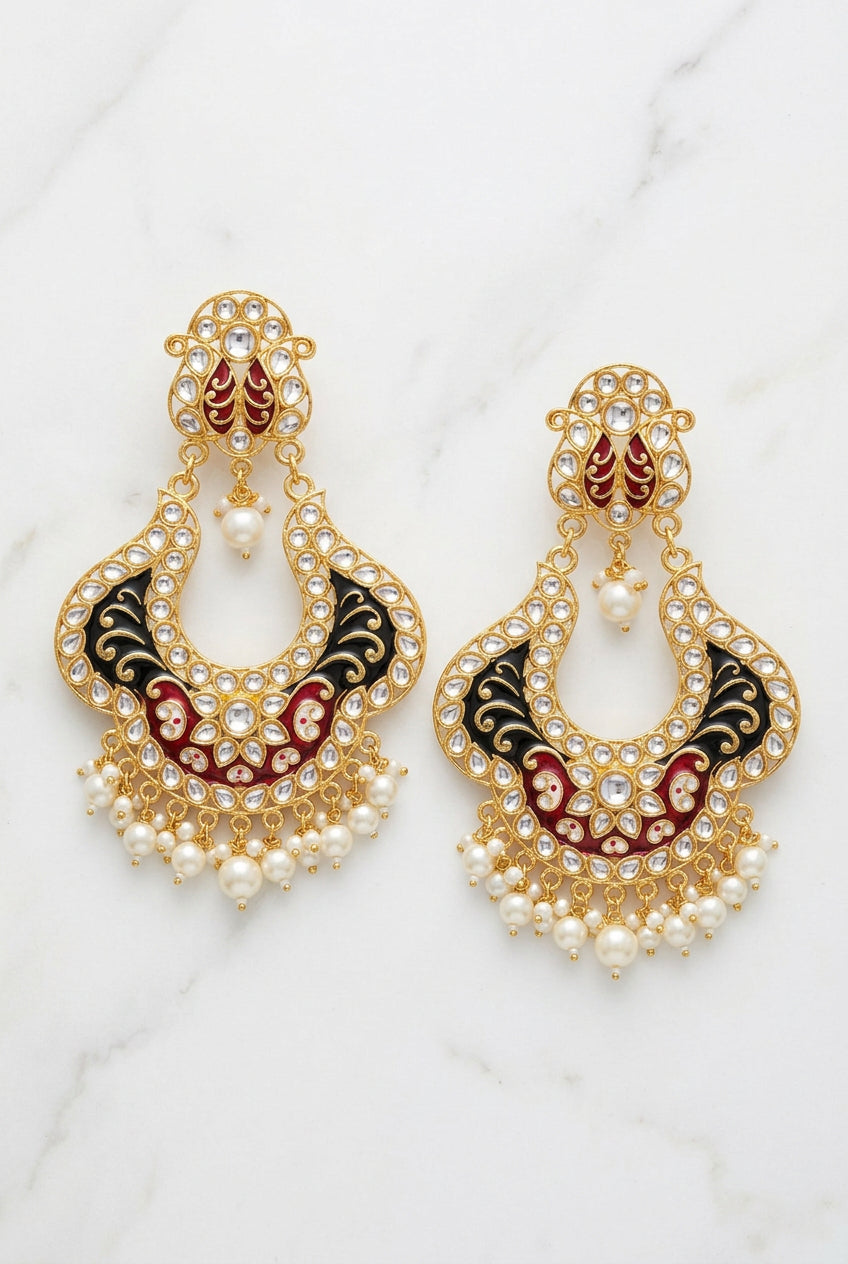 Pair of ornate earrings on a textured surface