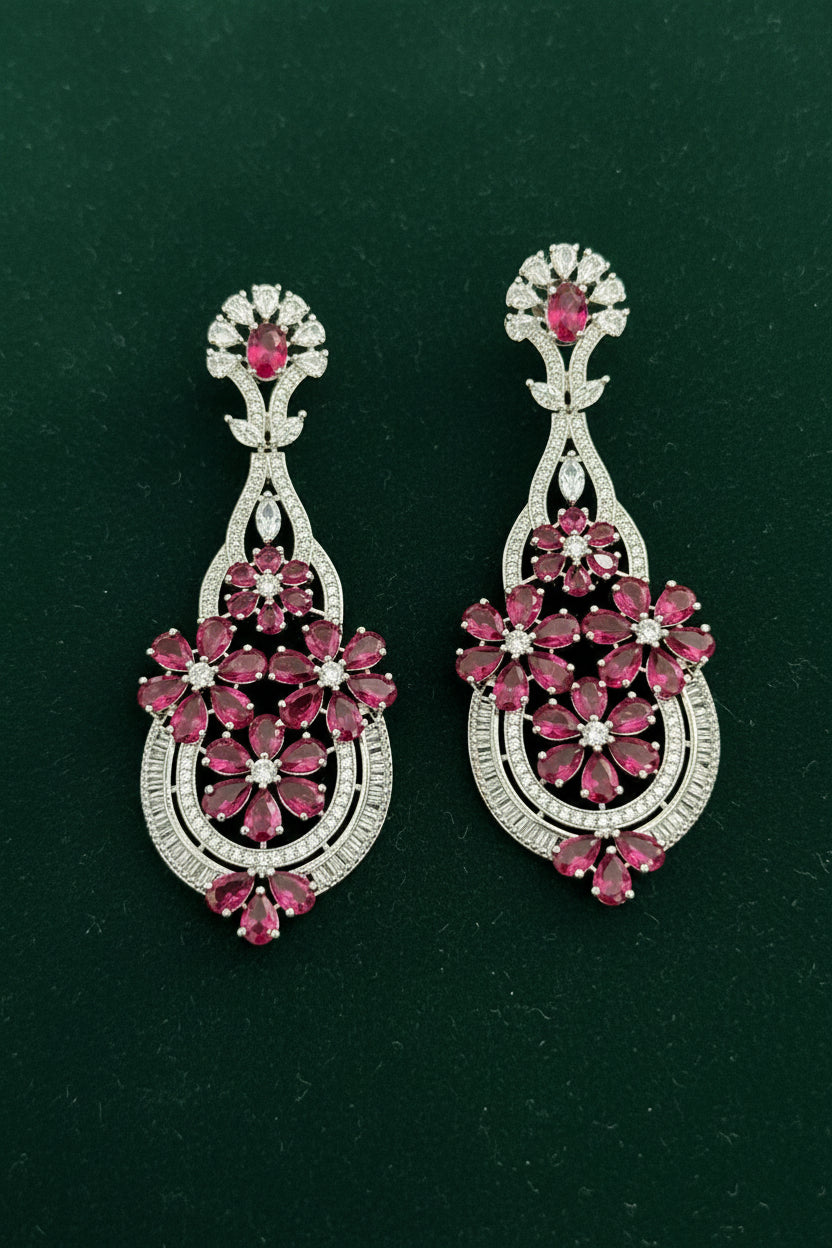 Pair of ornate earrings with floral designs on a black background