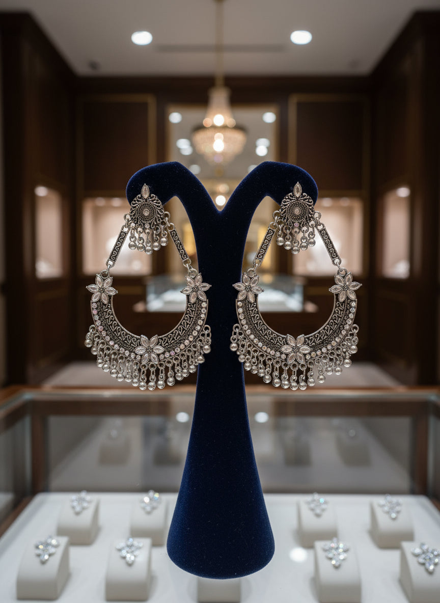 Pair of ornate silver earrings by famaza couture 