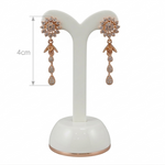 Pair of rose gold earrings on a white stand with measurement label