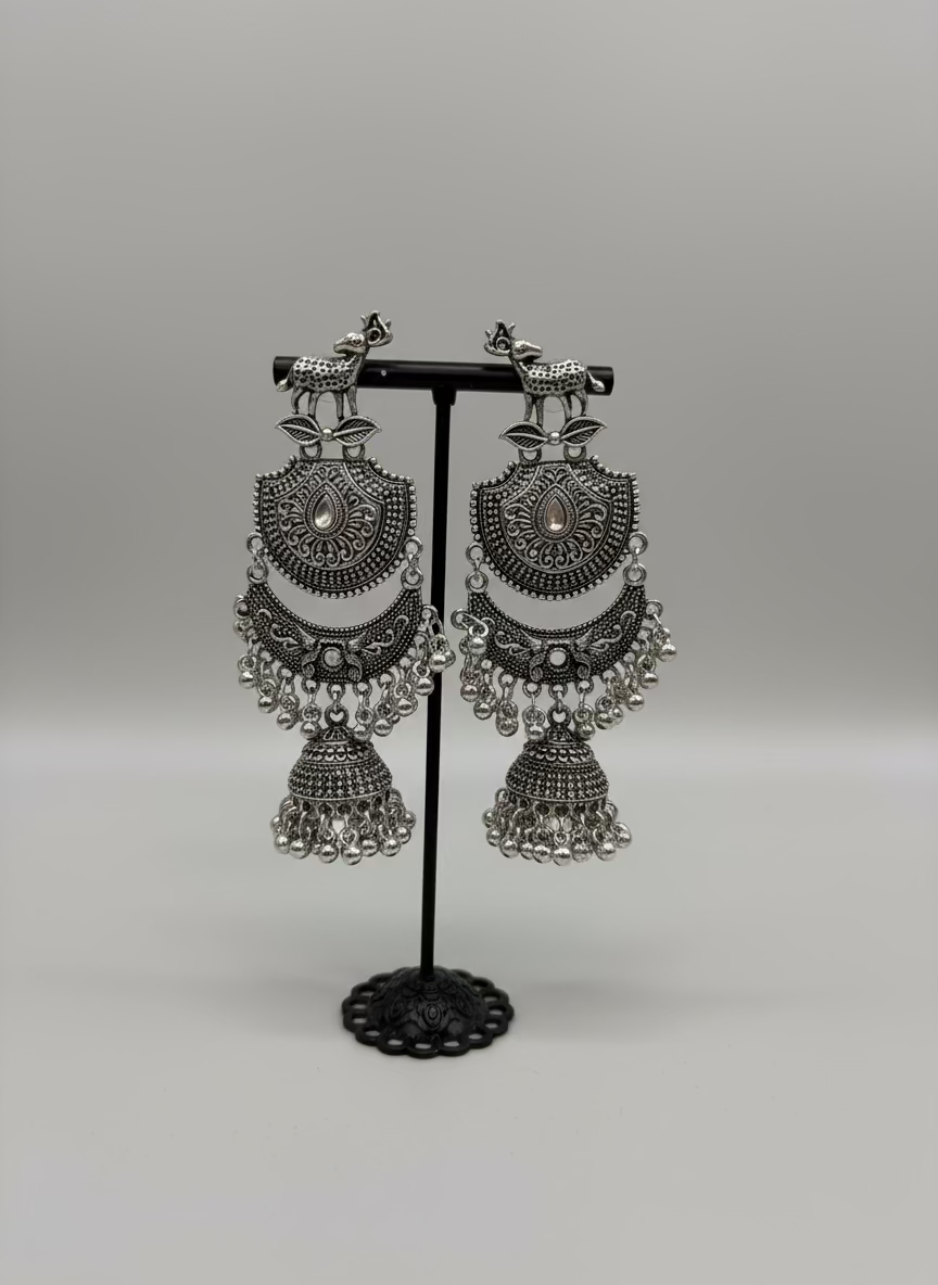 Pair of silver oxidised earrings with deer figure on the stud and chaand bali in drop with small jhumka in the bottom by famaza couture 