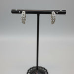 Pair of silver white stone curved bar earrings highlighting the 1.5cm length.