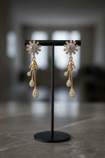 Pair of white stone rose gold earrings highlighting the contemporary infinity design and 4.5cm length.