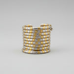 Parvati Dual-Tone Metallic Spiral Cuff Bracelet by Famaza Couture — gold and silver two-tone coiled spiral bracelet on luxury display tray