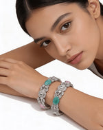 Close up of mint green and rose pink pastel stones with geometric baguette diamonds on slip-on silver bangles